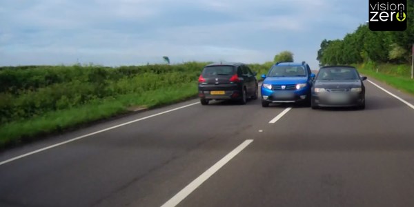 Two lanes, three cars in a row. Middle car squeezing between other two cars