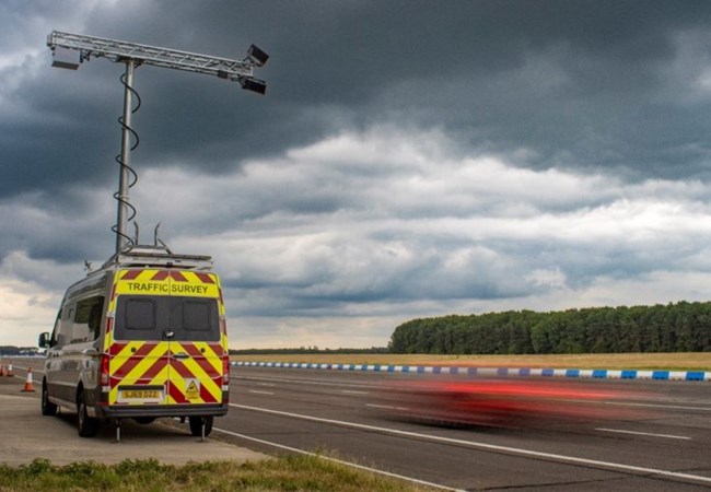 Speed cameras on top of a van by the side of a road